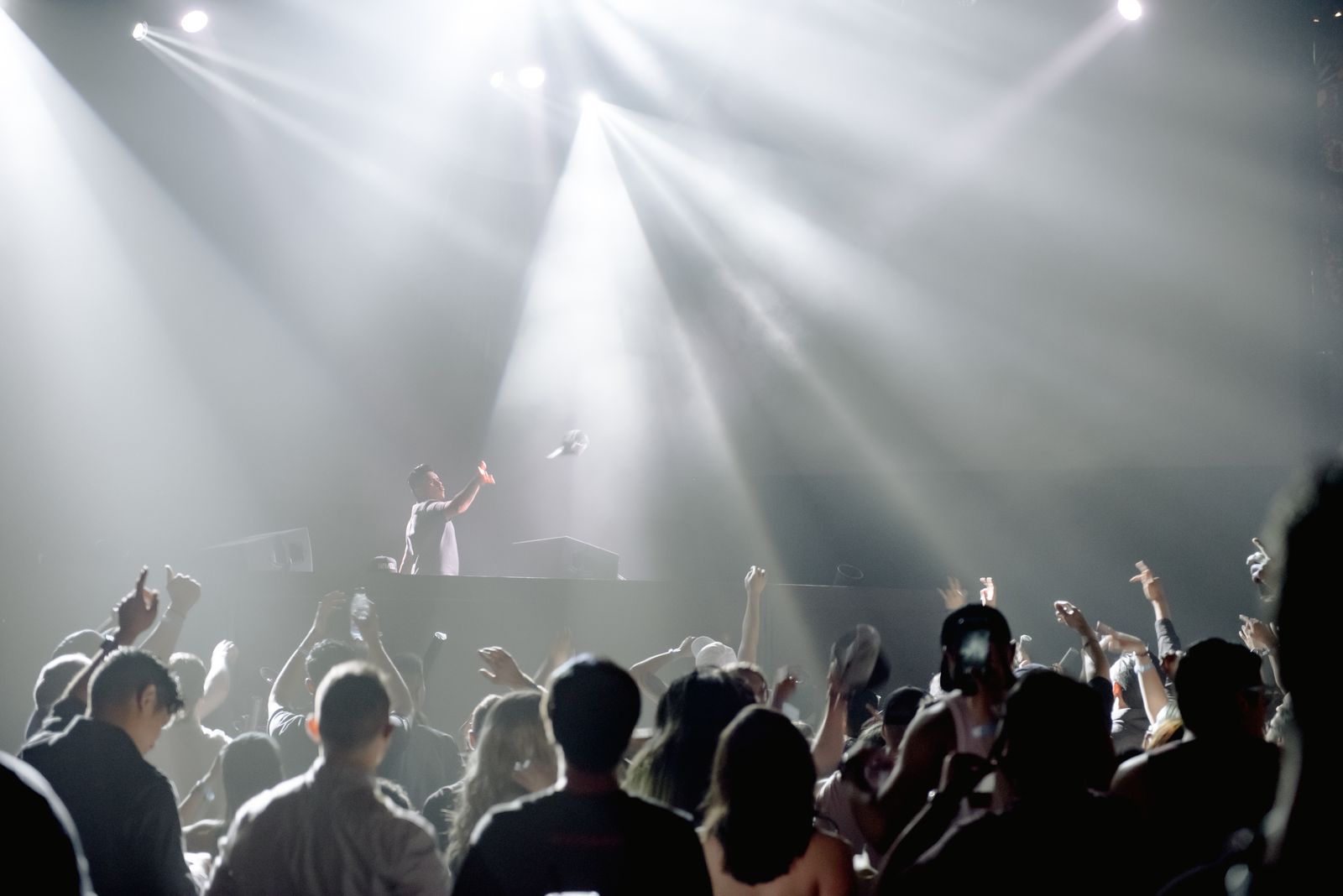 DJ performing to a crowd in a bright club room